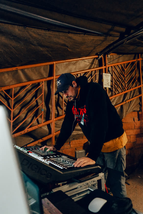 Technician working at an outdoor equipment bench under a pergola