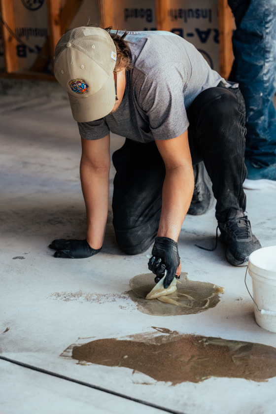 Contractor troweling mortar across a floor