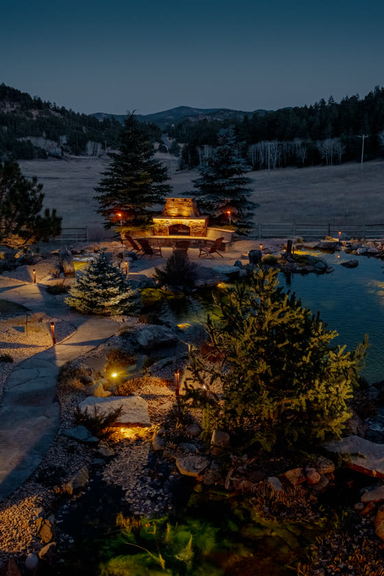 Landscape lighting around a pond at dusk
