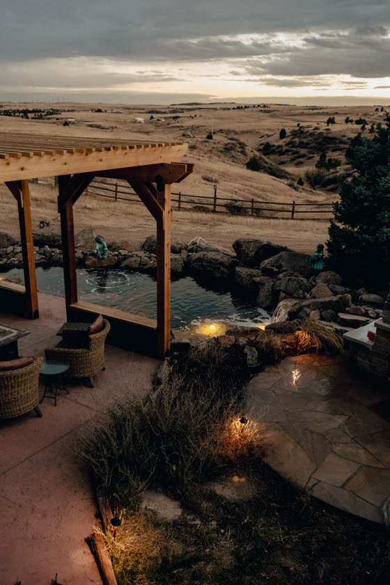 Pergola and patio overlooking a pond at sunset